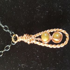 Wooden beads hand woven in gold with the black chain